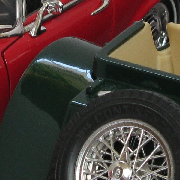Close-up of a vintage car model wheel and fender.