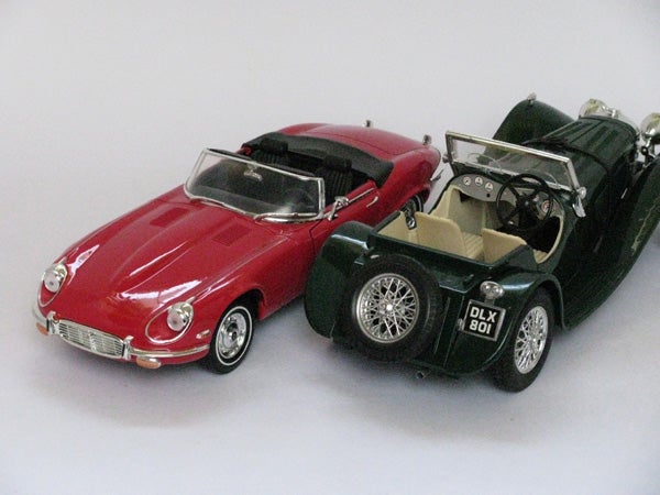 Two toy model cars on a white surface.