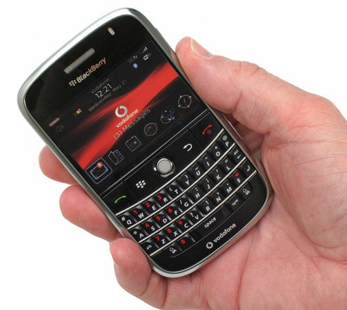 Hand holding a BlackBerry Bold 9000 smartphone.