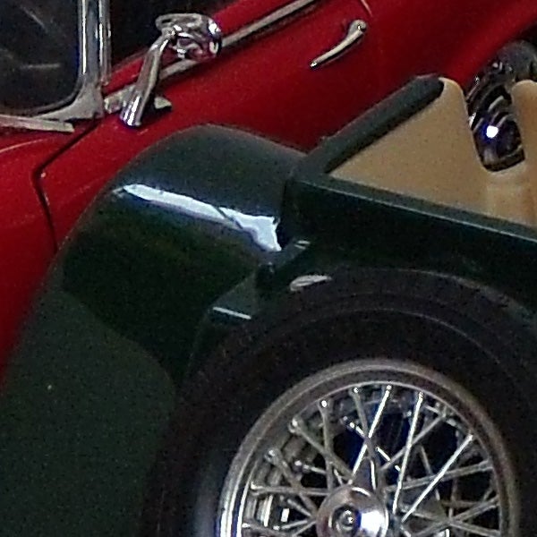Close-up of a vintage car wheel and fender.