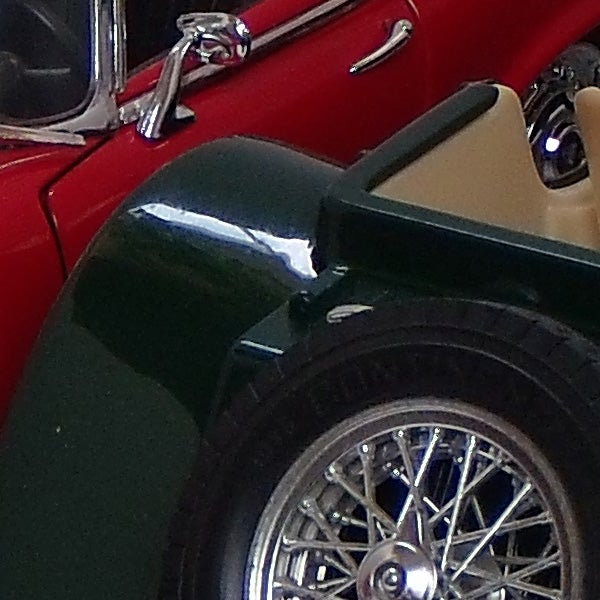 Close-up of a vintage car's wheel and fender.
