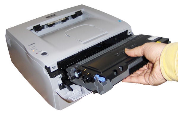 Hand replacing toner cartridge in Brother HL-2035 printer.