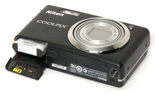 Nikon CoolPix S560 camera with open battery compartment.