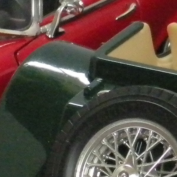 Close-up photo of vintage car fender and wheel.