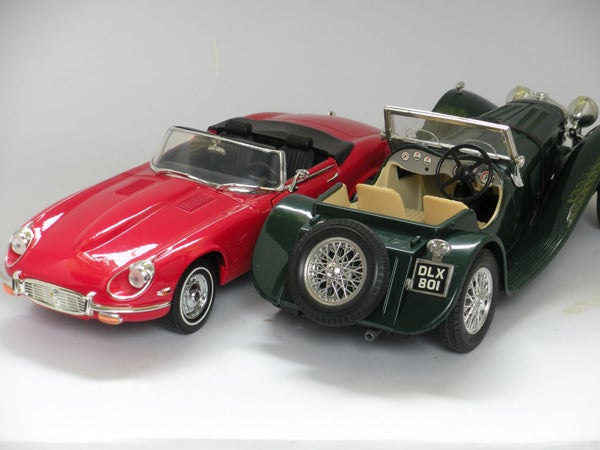 Toy model cars, red convertible and green classic roadster.