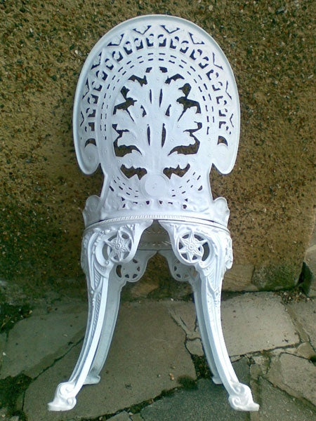 White ornate metal chair on a pavement
