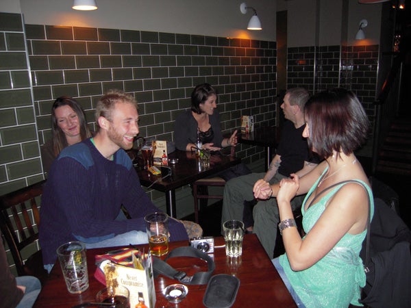 Group of people socializing in a restaurant/pub setting.