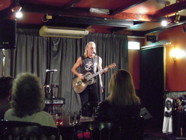 Musician performing live on stage at a small venue
