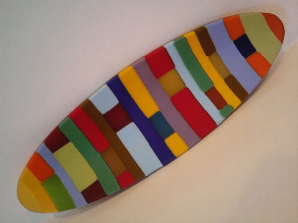 Colorful abstract ceramic piece on white background.