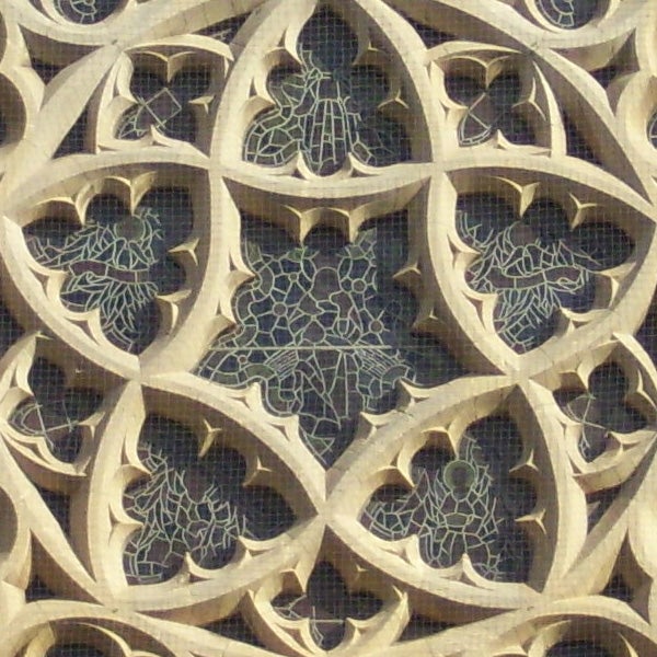 Intricate stone lattice window design with grape leaf patterns