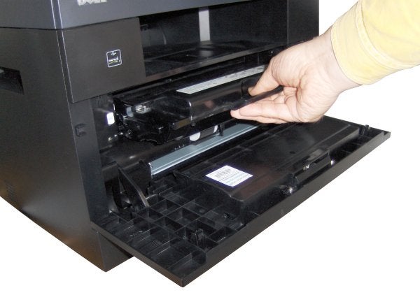 Person replacing toner in Dell 2335dn laser printer.