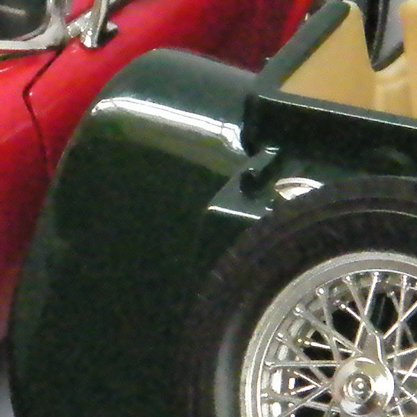 Close-up detail of a red and green toy car wheel.