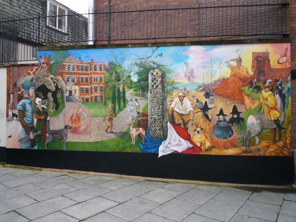 Colorful outdoor mural with various historical and fantasy figures.