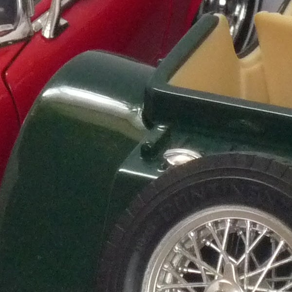 Close-up of a classic car's rear wheel and fender.