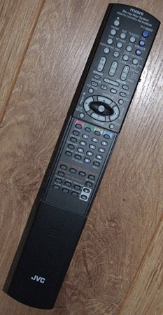 JVC NX-BD3 system remote control on wooden floor.