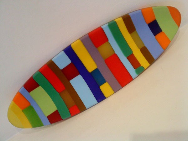 Colorful surfboard-shaped artwork on white background.
