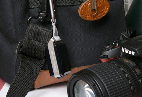 ATP Photo Finder Mini attached to a camera bag beside a Nikon lens.