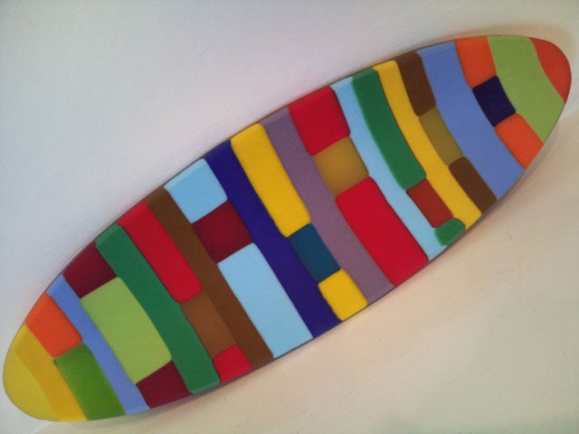 Colorful abstract painted surfboard on white background.
