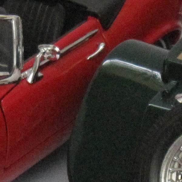 Close-up of red car door and side mirror.