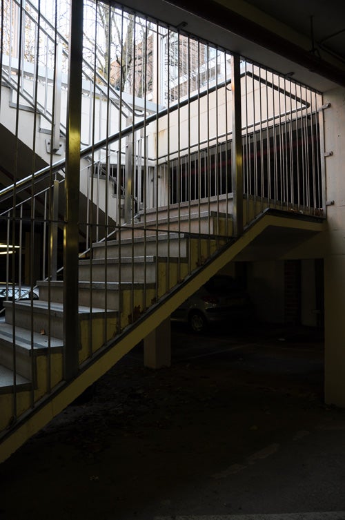 Interior of a dimly lit parking garage with stairs.