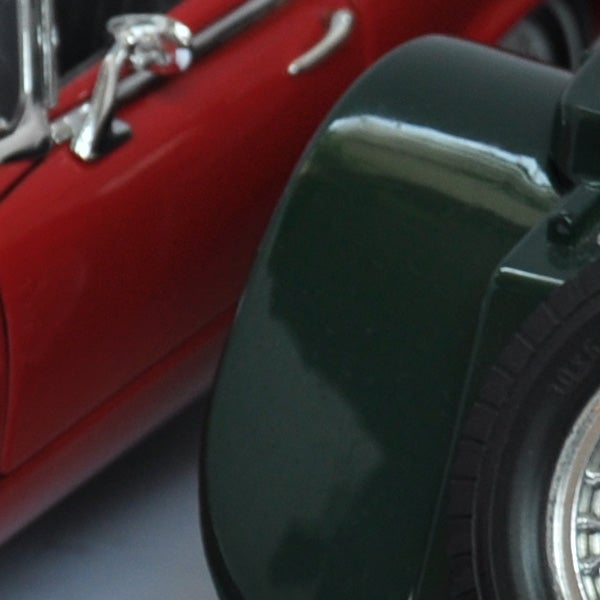 Close-up photo of a red toy car and camera lens.