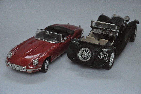 Two toy car models photographed in soft lighting.
