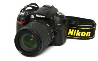 Nikon D90 digital SLR camera with lens and strap.