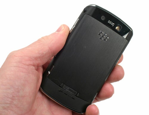 Hand holding a BlackBerry Storm smartphone from the back.