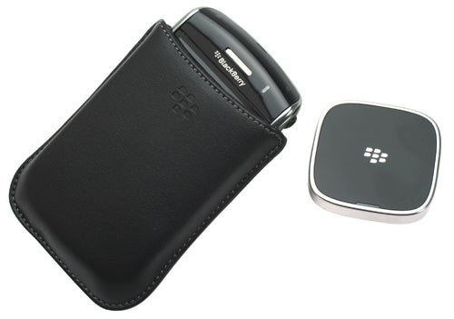 BlackBerry Storm smartphone with case and Bluetooth device.