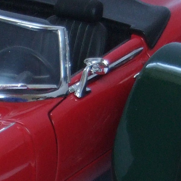 Close-up of red toy car details with chrome parts.