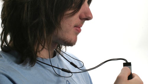 Man wearing Sennheiser MM200 Bluetooth headset looking at device.
