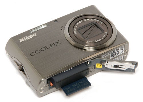 Nikon CoolPix S710 camera with open battery compartment.