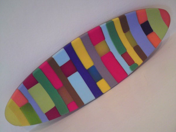 Colorful abstract surfboard-shaped object on white background.