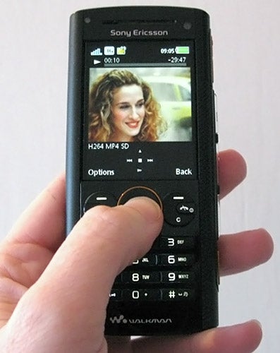 Hand holding a Sony Ericsson W902 mobile phone.
