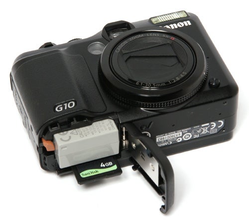 Canon PowerShot G10 camera with battery compartment open.