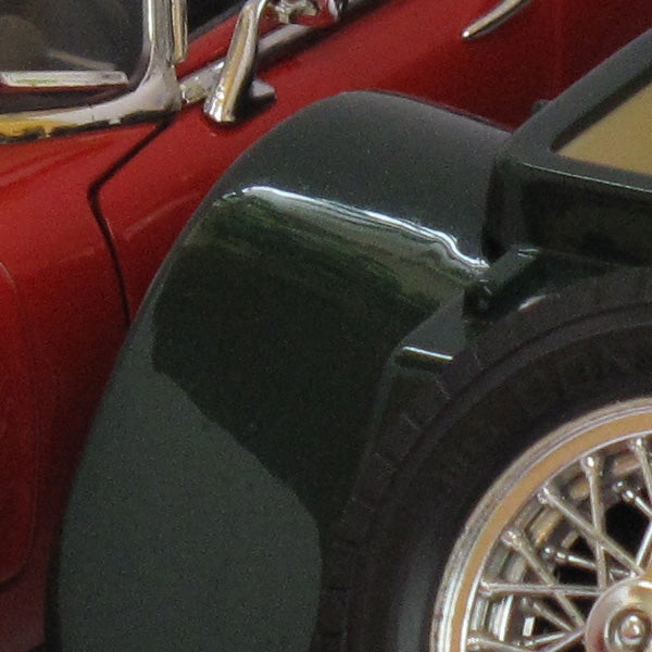 Close-up of a red vintage car's fender and headlight