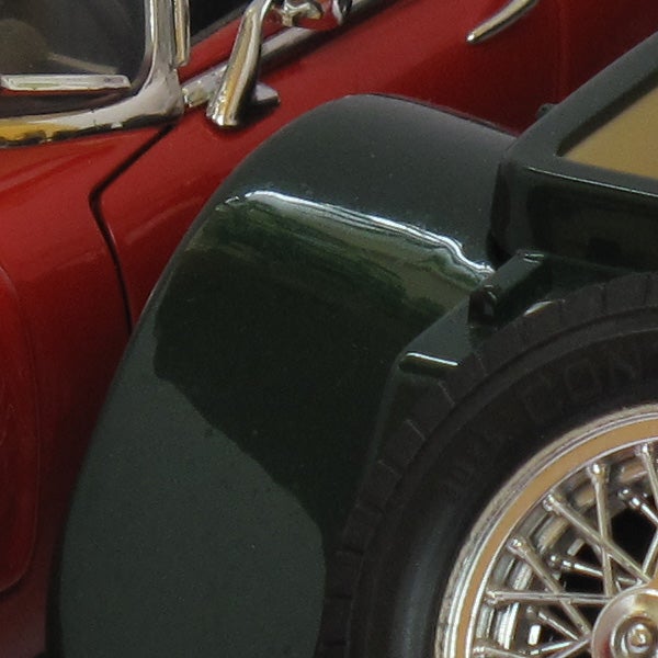 Close-up of a red vintage car's wheel and fender