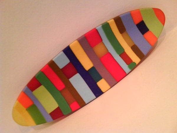 Colorful abstract patterned surfboard on white background