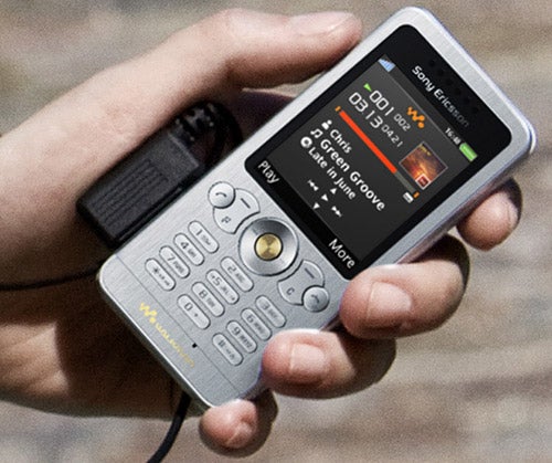 Hand holding a Sony Ericsson W302 Walkman phone.
