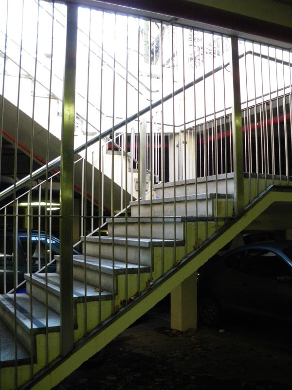 Concrete staircase in a parking garage with metal railings