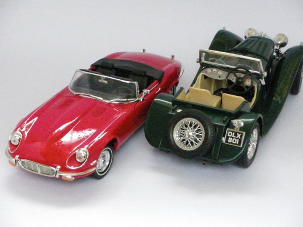 Red and green vintage toy cars on a white background