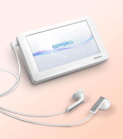 Cowon O2 media player with earphones on a pink surface.