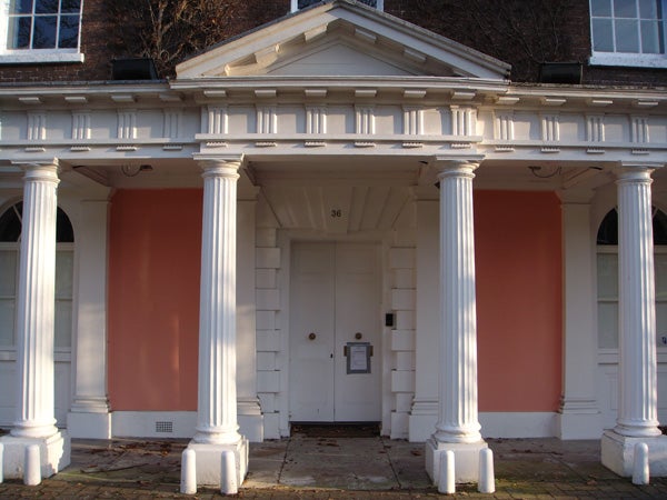 White-columned building entrance with shadows captured by Sony camera.