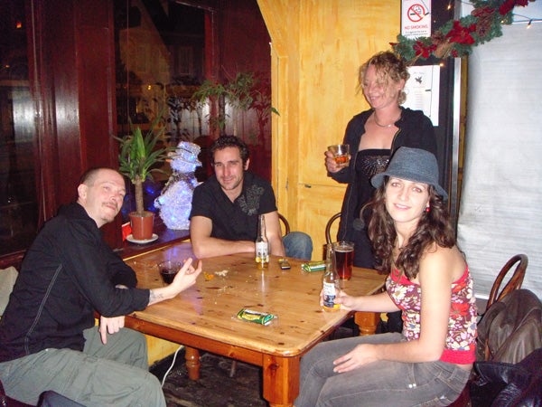Group of people enjoying drinks at a pub table.