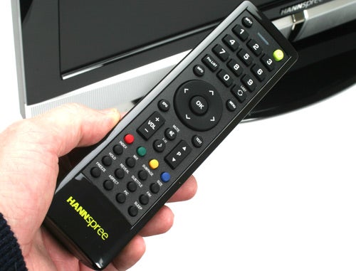 Hand holding a Hannspree HT09 TV remote control.
