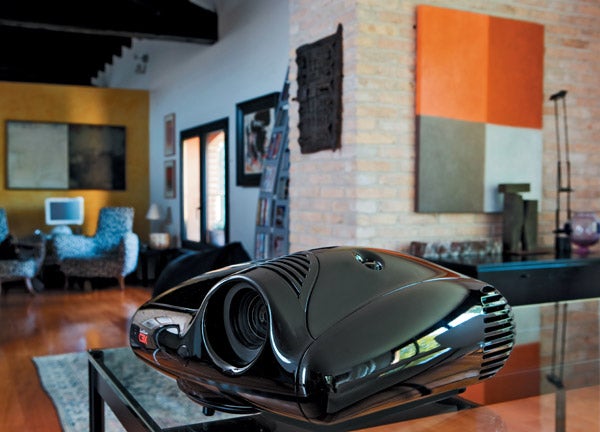 SIM2 Grand Cinema C3X 1080 Projector in modern living room setting.