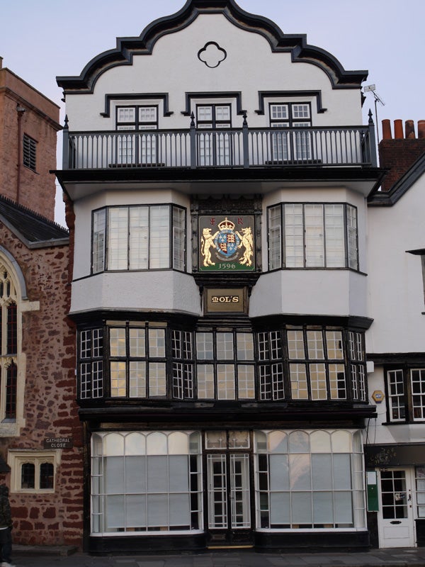Traditional black and white timber-framed building with a crest.