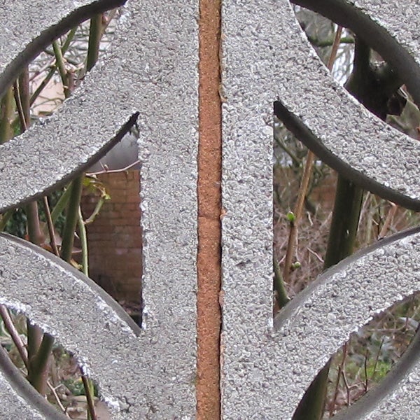 Close-up of frost on metal gate with background.