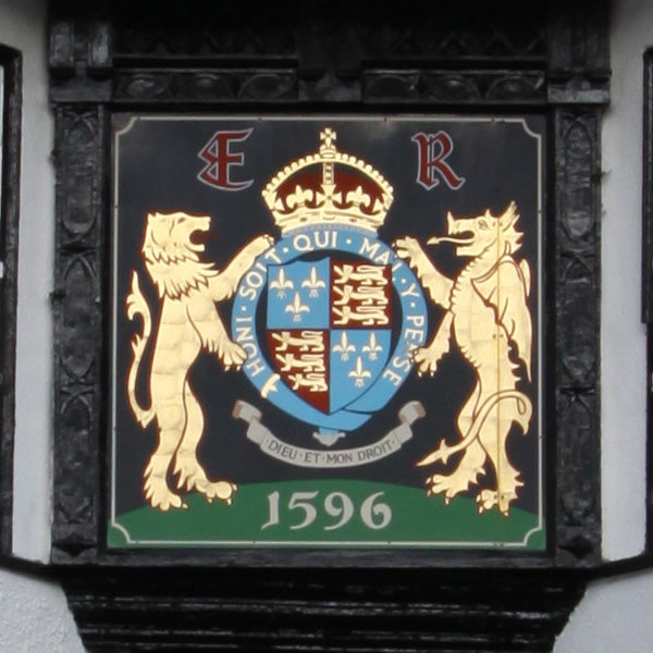 Coat of arms on a plaque with lions and a crown.