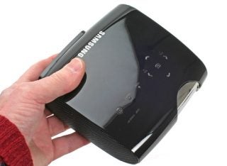 Hand holding Samsung SP-P400B portable projector.